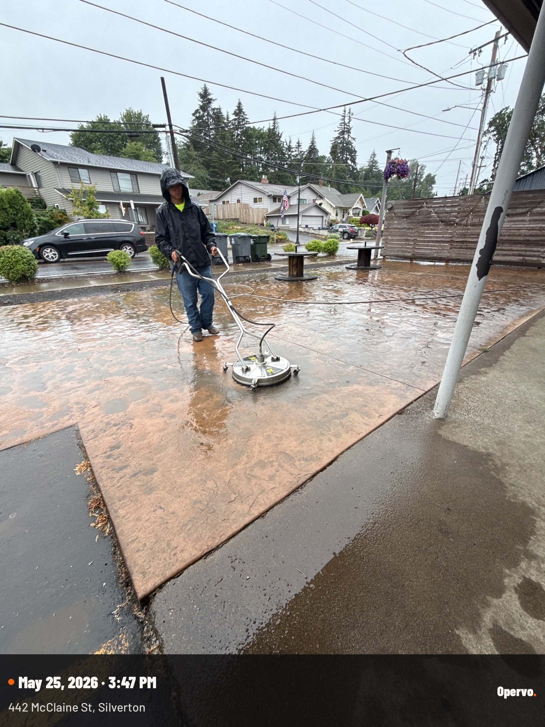 Code 3 Cleaning operator using a rotary surface cleaner to pressure-wash a driveway.